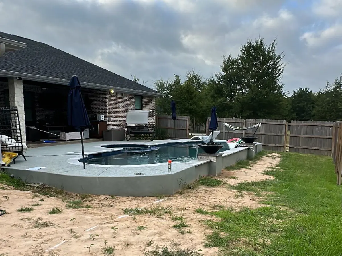 A backyard pool on a concrete patio