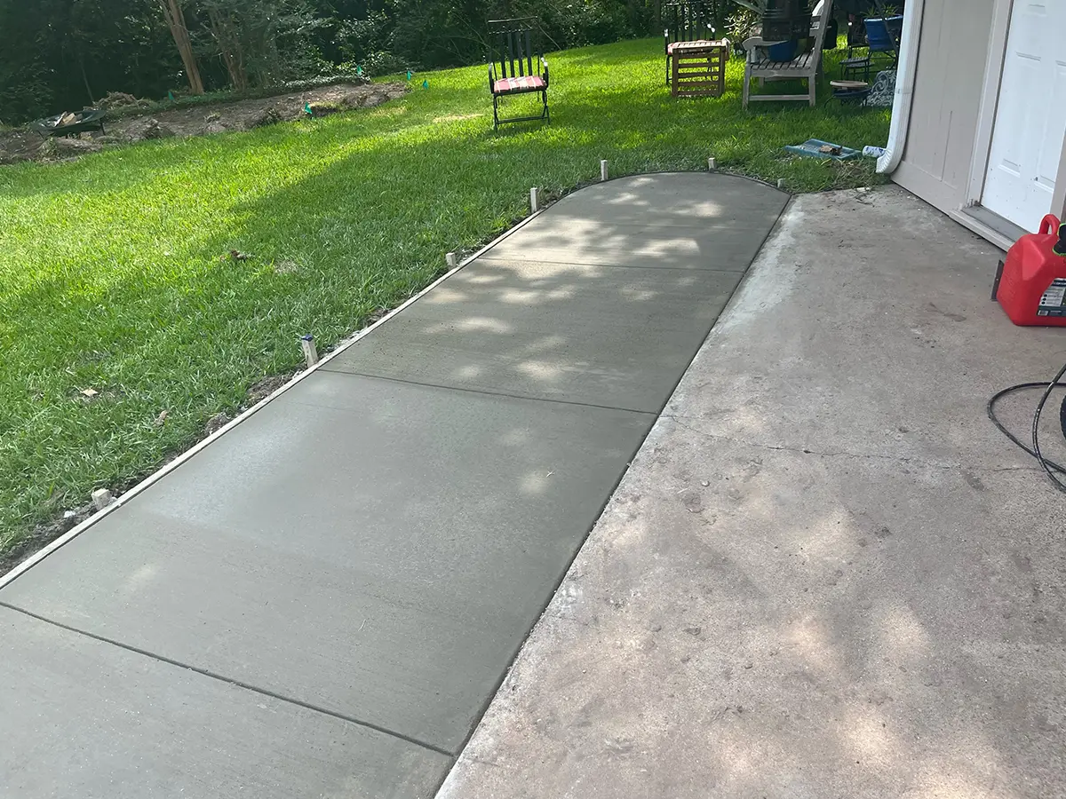A fresh concrete patio for a backyard with a nice patch of grass