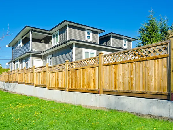 A cedar privacy fence with a concrete foundation