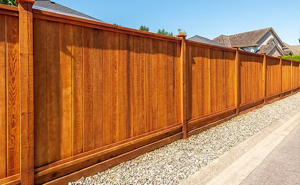 A cedar privacy fence and gravel surrounding it