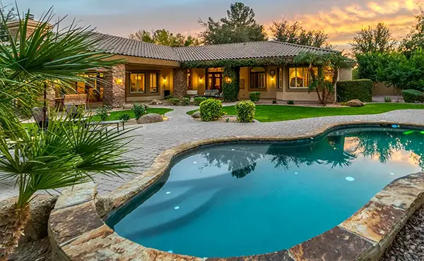 A beautiful pool and a large walkway and patio made of pavers