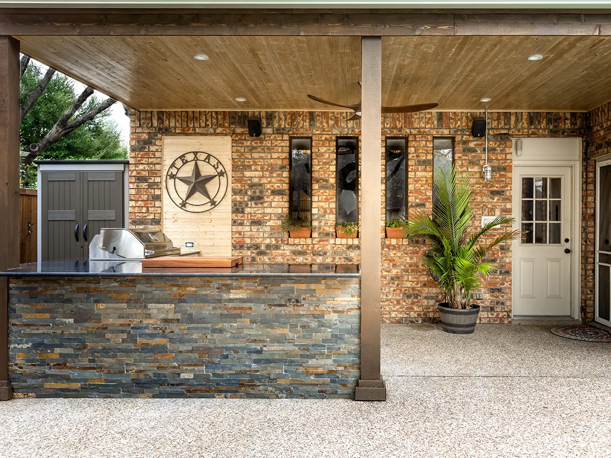 An outdoor kitchen island with stone veneer siding