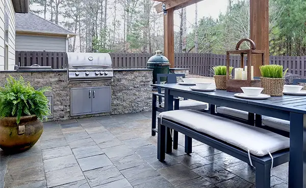 An outdoor kitchen with a stamped concrete patio