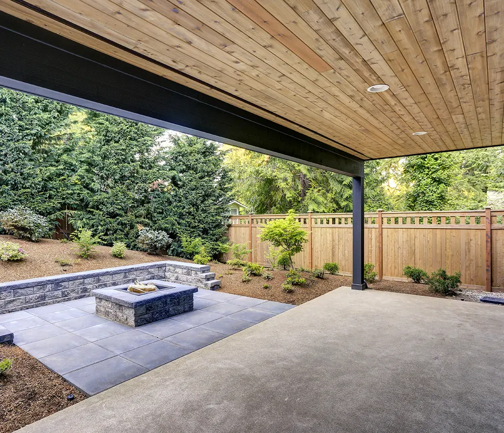 A concrete patio with a square firepit