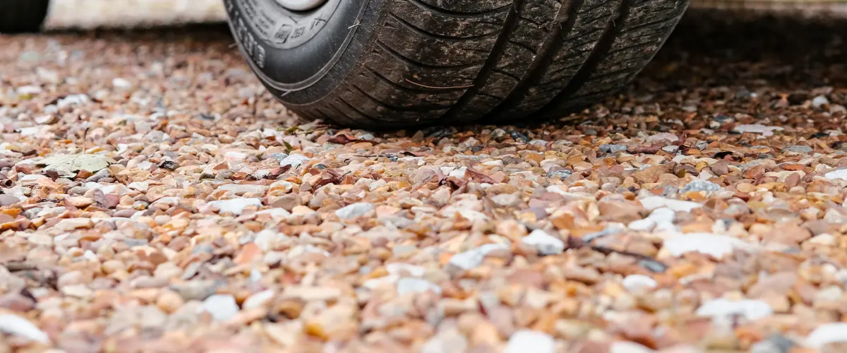 Close-up of a car tire on a gravel driveway