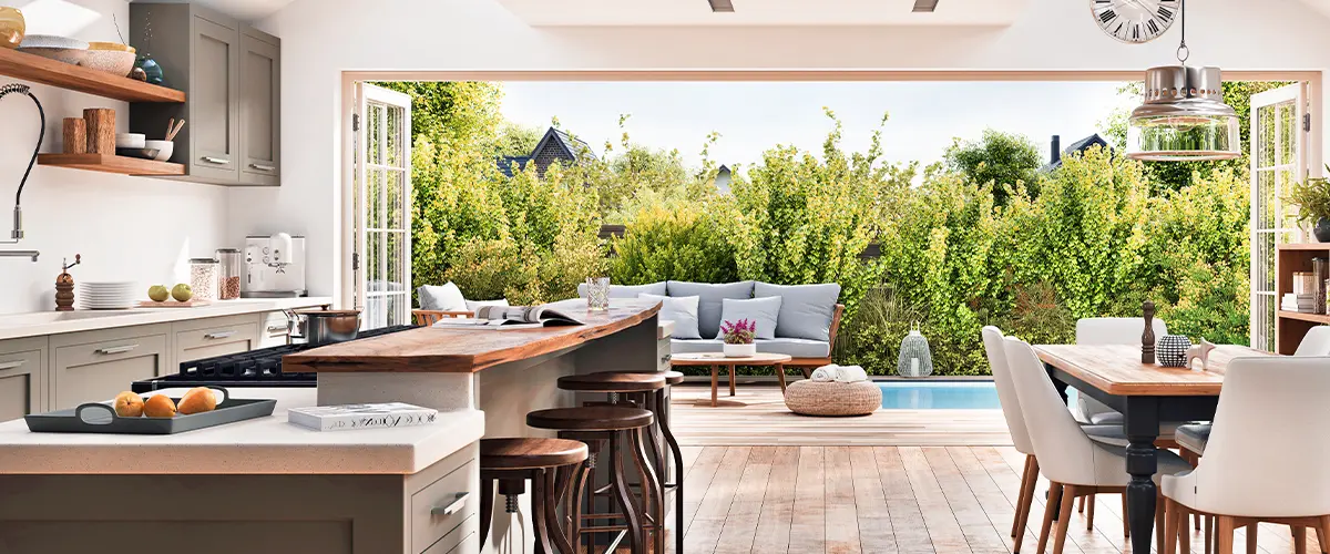 Bright open-concept kitchen and dining area with skylights, natural light, and a view of the green backyard.