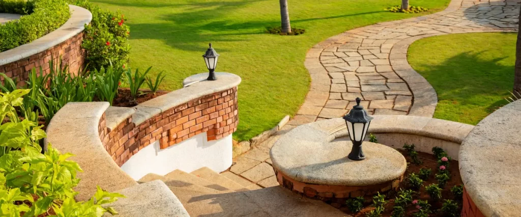 Curved stone walkway with decorative lighting and elevated landscaping