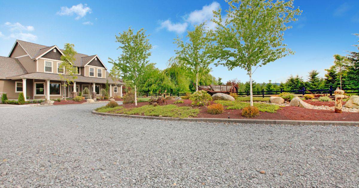 Gravel driveway in front of a suburban home with landscaping