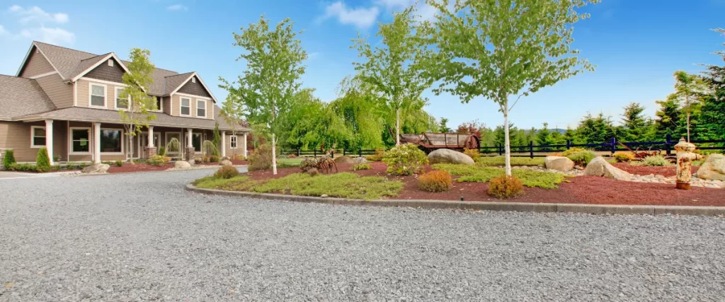 Circular gravel driveway with landscaped center and surrounding trees