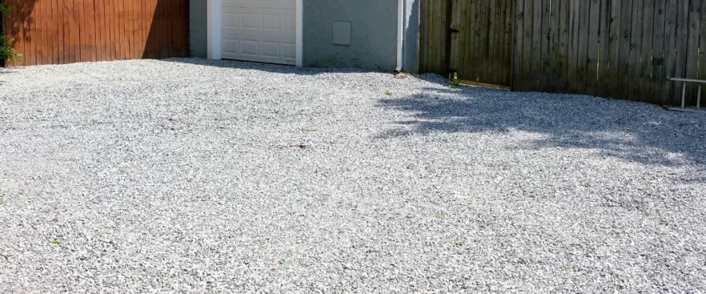 Gravel driveway leading up to a garage
