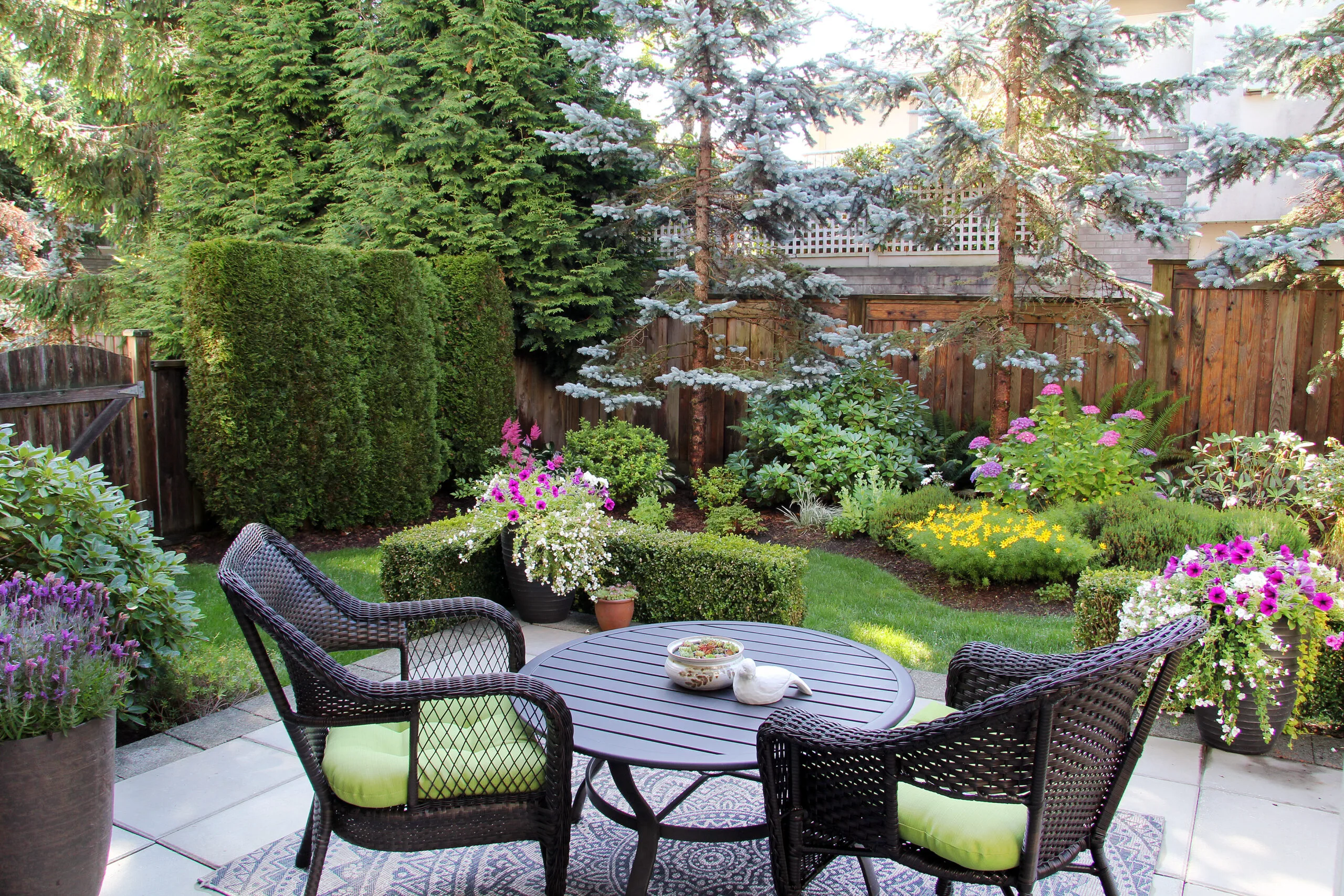 Outdoor living space with lush landscaping, wicker chairs, and a modern garden patio in Southwood Valley, College Station, TX